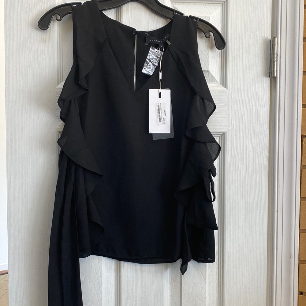 Sleeveless blouse. NWT. Ties on sides. Wide arm hole opening.